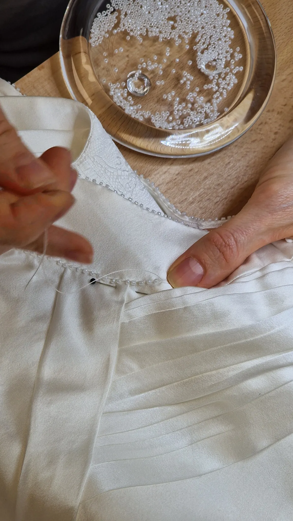 Careful hand stitching on white fabric