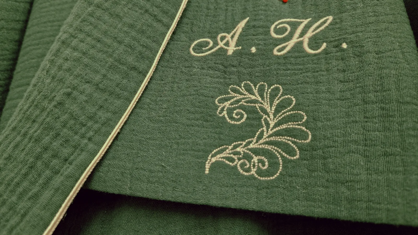 Personalised monogram embroidery on green fabric